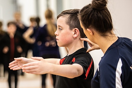 Dance Crazy Studios instructor adjusting young boy's posture